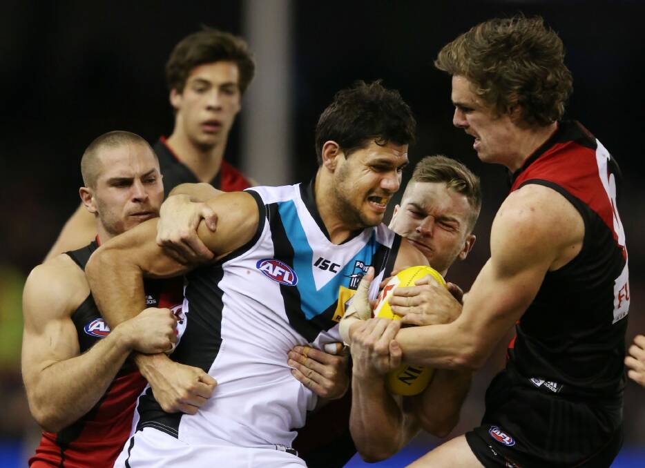Swamped: Port Adelaide's Patrick Ryder tackled by three Bombers. Photo: Getty Images