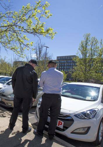 Two parking officers, who do not wish to be identified, conduct their rounds in parliamentary triangle car parks on the first day of enforced paid parking. Photo: Matt Bedford