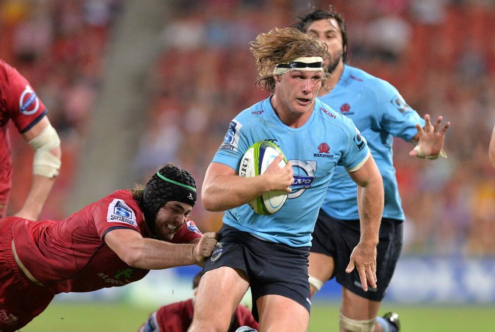 Flying Blue Michael Hooper breaks through the Reds' defence for the Waratahs. Photo: Getty Images