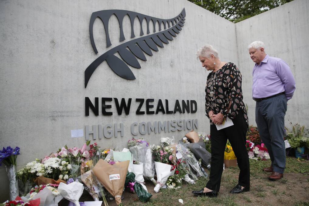 New Zealand High Commissioner Dame Annette King and husband Ray Lind view flowers left at the front gate of the high commission in Canberra on Sunday, following the mass shooting in Christchurch Photo: Alex Ellinghausen