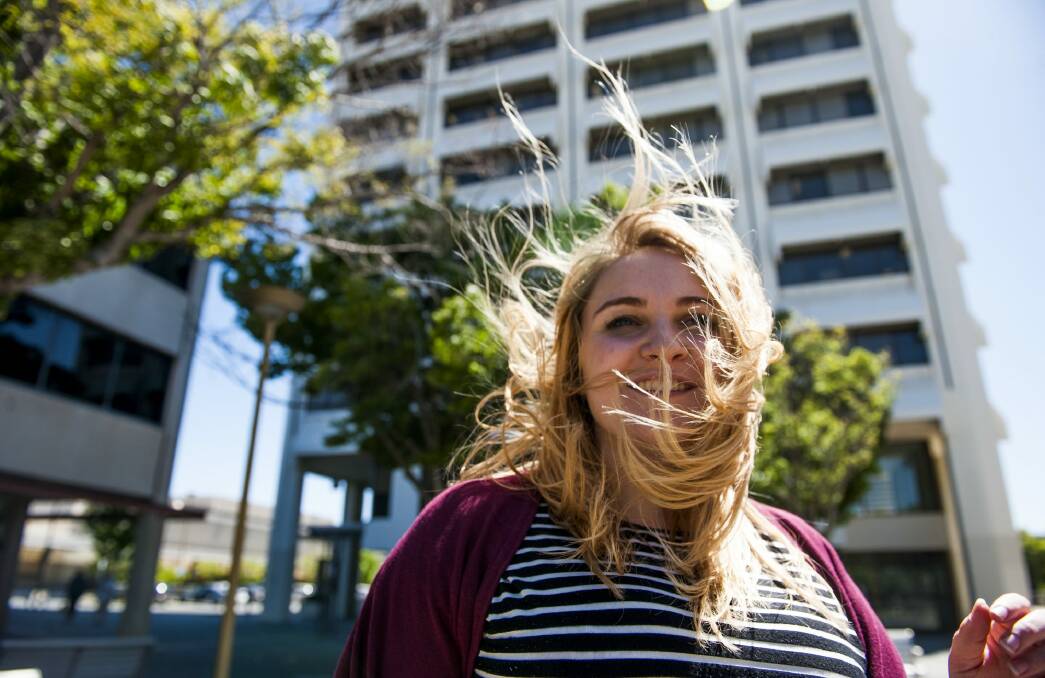 Laura Corrigan, of Holder, tries to tame her hair in the wind in Woden Square on Thursday.  Photo: Elesa Kurtz
