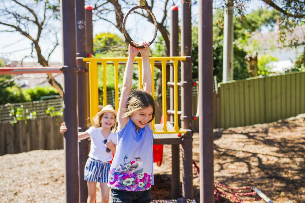 Sisters Olivia and Sophia Baker can keep playing in Narrabundah playground after the ACT government decided to repair it. Photo: Jamila Toderas