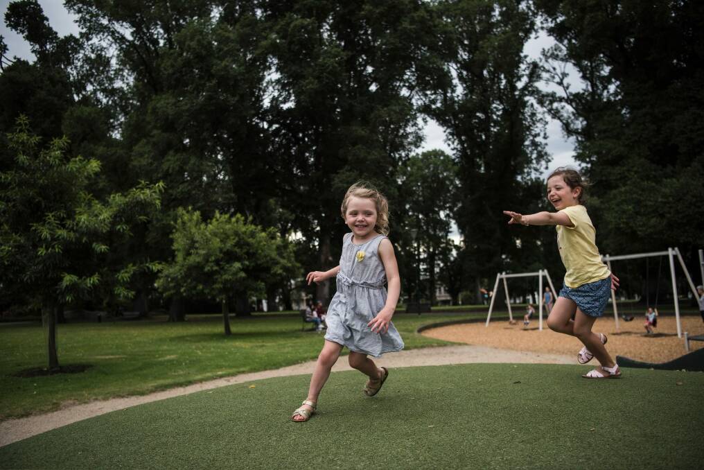 Sisters Ruby and Evie play in the Carlton Gardens. Photo: Josh Robenstone