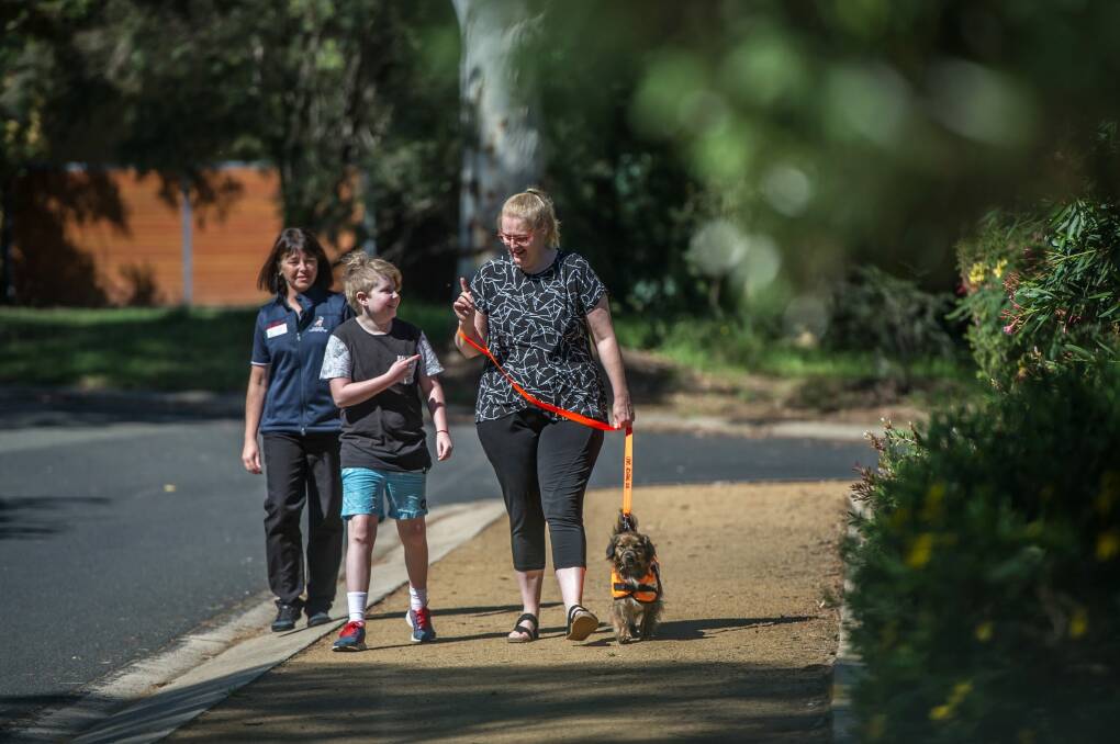 Jo Gale from the Australian Lions Hearing Dogs trainer watches progress of Amanda Sullivan with 10-year-old son, Tristan Sullivan with their new service dog Daphne.  Photo: Karleen Minney