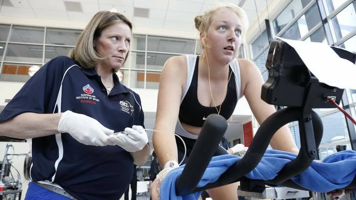 Dr Megan Ross draws blood from cyclist Alice Wallett during tests at the AIS. Photo: Jeffrey Chan