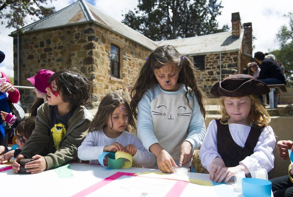 Darius, 7, Yasmin, 5 and Aaliyah Nanva, 9, and Elizabeth Parton, 5, take part in creating a paper chain at the Blundell's Cottage Gala Day. Photo: Elesa Kurtz