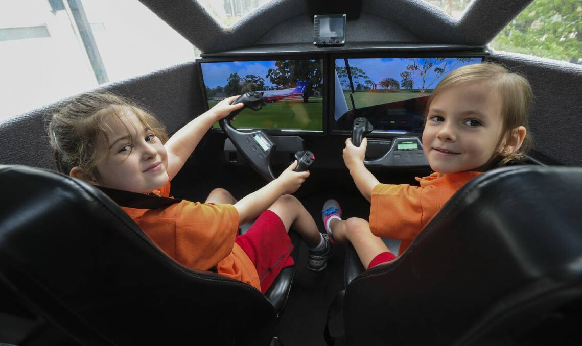 "Pilot to co-pilot", five-year-olds, Alannah Amos, left, and Khloee Owen take the controls. Photo: Graham Tidy