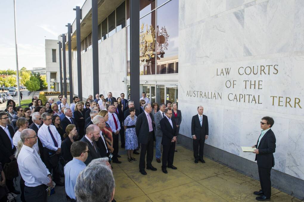 ACT Bar Association president Shane Gill, right, leads members of the legal profession in a minute's silence outside the ACT Supreme Court. Photo: Rohan Thomson