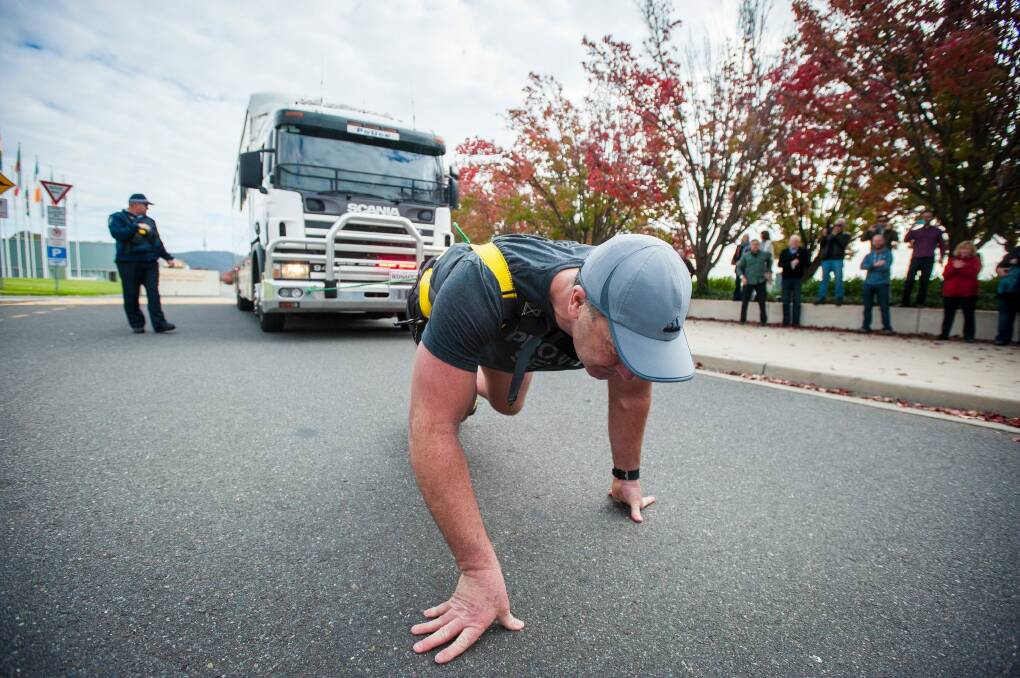 AFP Commander Grant Edwards pulls a 14-tonne police truck to prepare for his attempt at breaking a Guinness World Record.  Photo: Dion Georgopoulos