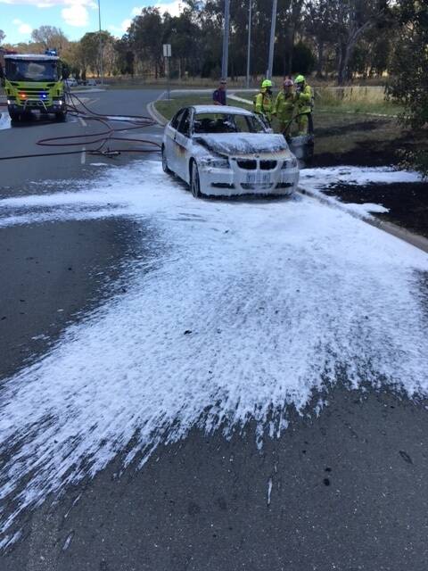 ACT Fire and Rescue put out the car fire while passers-by put out the grass fire. Photo: Supplied