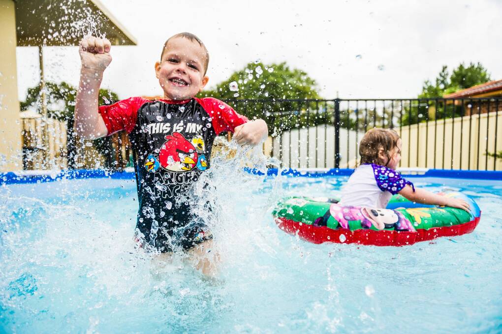Ethan, 4, and Aislinn, 2, Hastings play in their temporary pool at home in south Canberra. Photo: Rohan Thomson