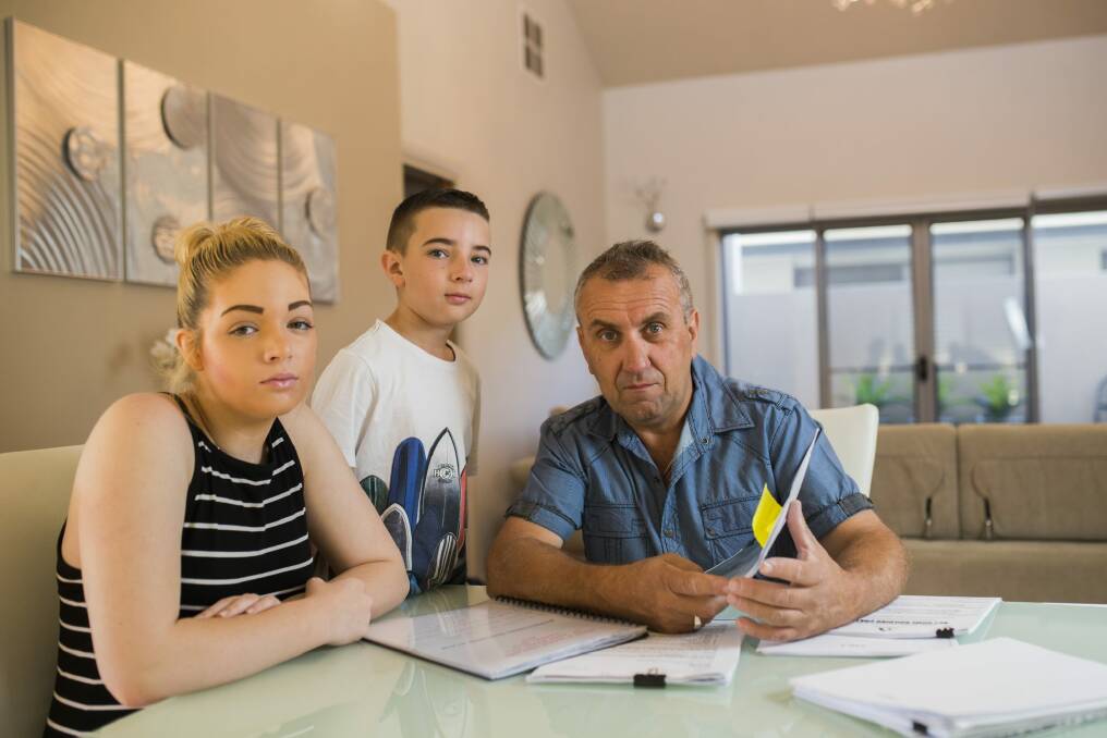 Chantelle, Ethan,10, and John Ireland at their home in Forde. The home has structural damage which QBE insurance is refusing to cover.  Photo: Rohan Thomson