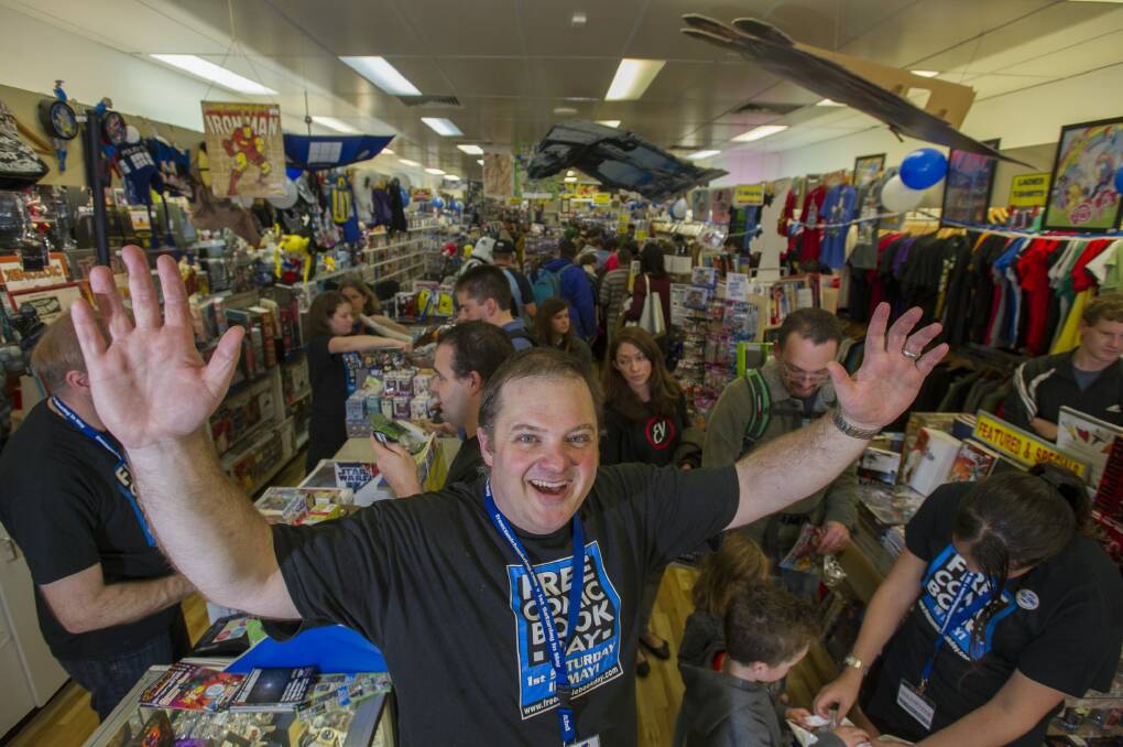 Impact Comics owner Mal Briggs treating comic book fans at his store as part of the international Free Comic Book Day. Photo: Jay Cronan