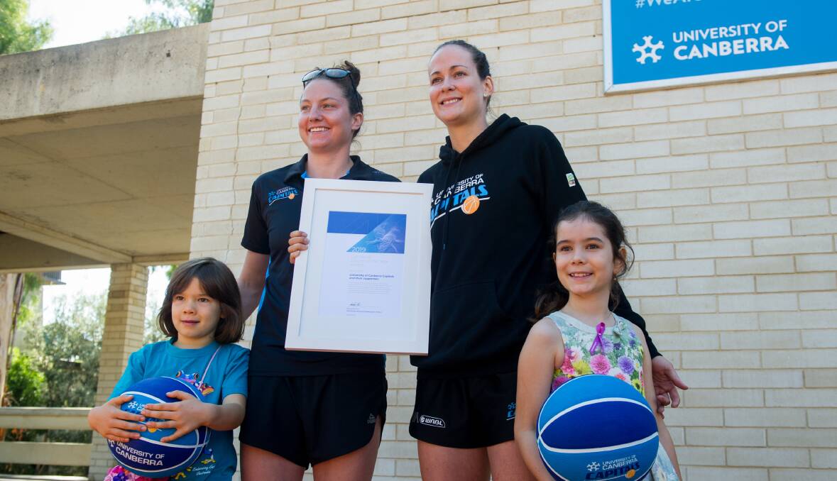 The Canberra Capitals players Kelsey Griffin and Keely Froling at the announcement the team and its supporters were the 2019 Canberra Citizen of the Year. Pictured with them are the team's No 1 ticket holder Daliah Lee, eight, (right) and her sister Heidi, six. Photo: Elesa Kurtz