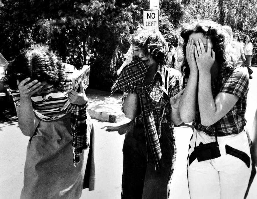 December 1975: Distraught Bay City Rollers fans at Canberra Airport, upset that band member Alan Longmuir was taken off the plane and put into a waiting ambulance suffering heat exhaustion. Photo: Staff