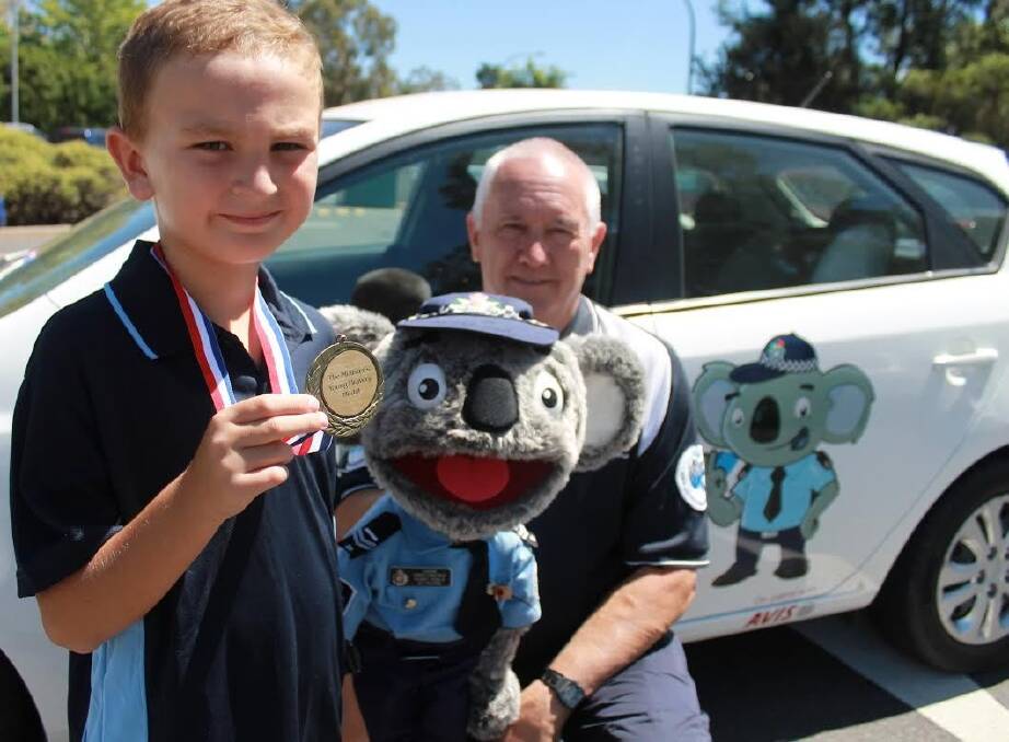 Evatt Primary School student Aaron Zorzi, who received a bravery medal for helping save his mother's life, with Constable Kenny Koala and Stewart Waters. Photo: Belle Thompson