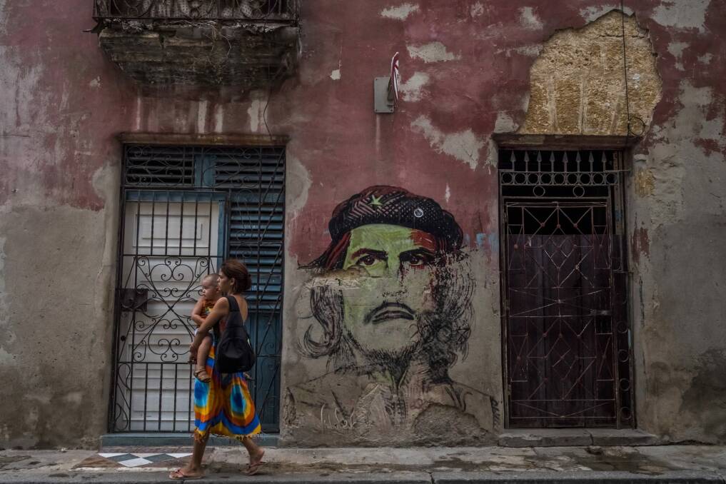 A woman carries a child along a street in Old Havana. Since the 1970s, the birthrate in Cuba has been in free fall. Photo: New York Times