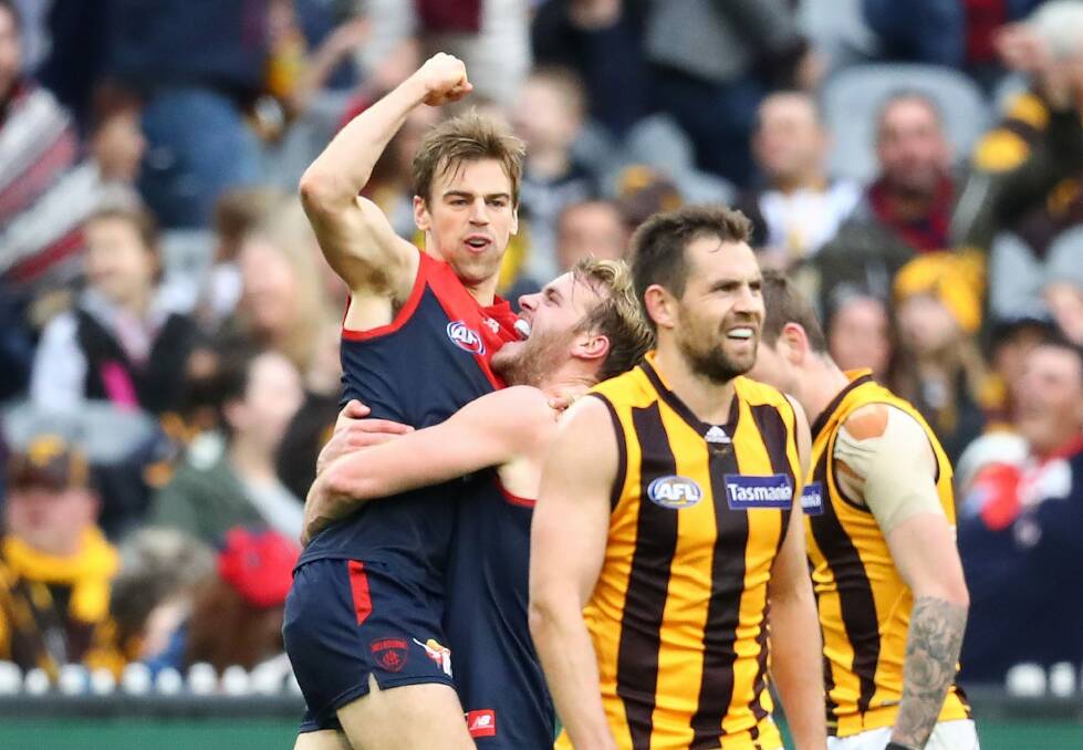  Luke Hodge of the Hawks looks dejected as Dom Tyson of the Demon. Photo: Getty Images / Scott Barbour