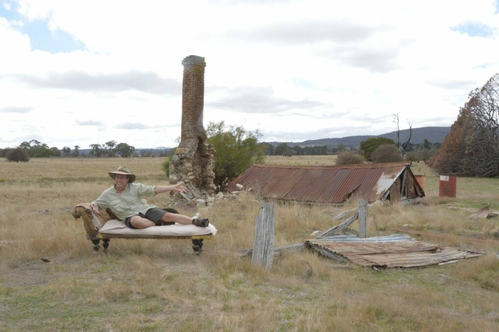 Tim lies on the antique chaise lounge which used to take pride of place in the parlour of this now "sunken house" near Collector. Photo: Gary Poile