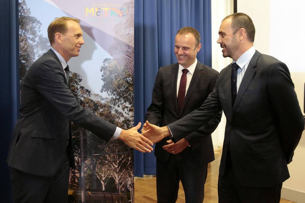 From left, ACT Deputy Chief Minister Simon Corbell, Chief Minister Andrew Barr and Canberra Metro Consortium chairman Mark Lynch shake hands as the winning tender is announced on February 1.   Photo: Jeffrey Chan