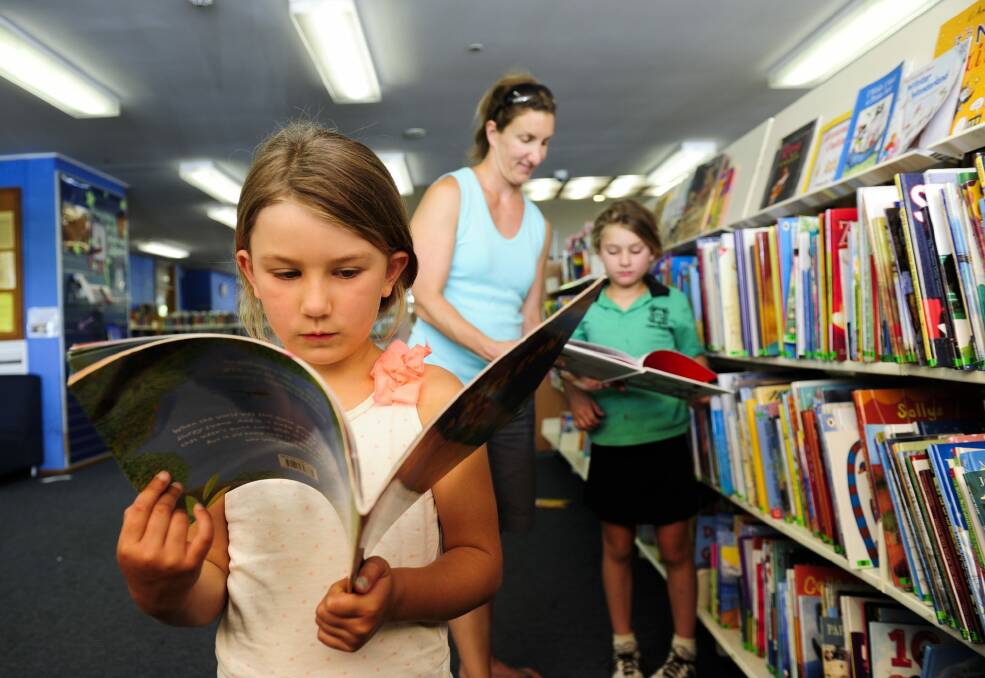 Mahdi Turner of O'Connor with her daughters front, Chloe, 5 and back, Zara, 7 at Dickson Library. Photo: Melissa Adams