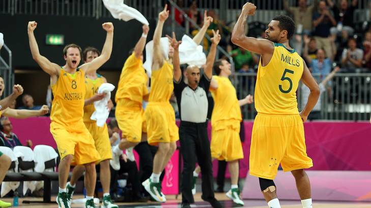 Canberra's Patrick Mills, right, celebrates his buzzer-beating three-pointer against Russia last night. Photo: Christian Petersen