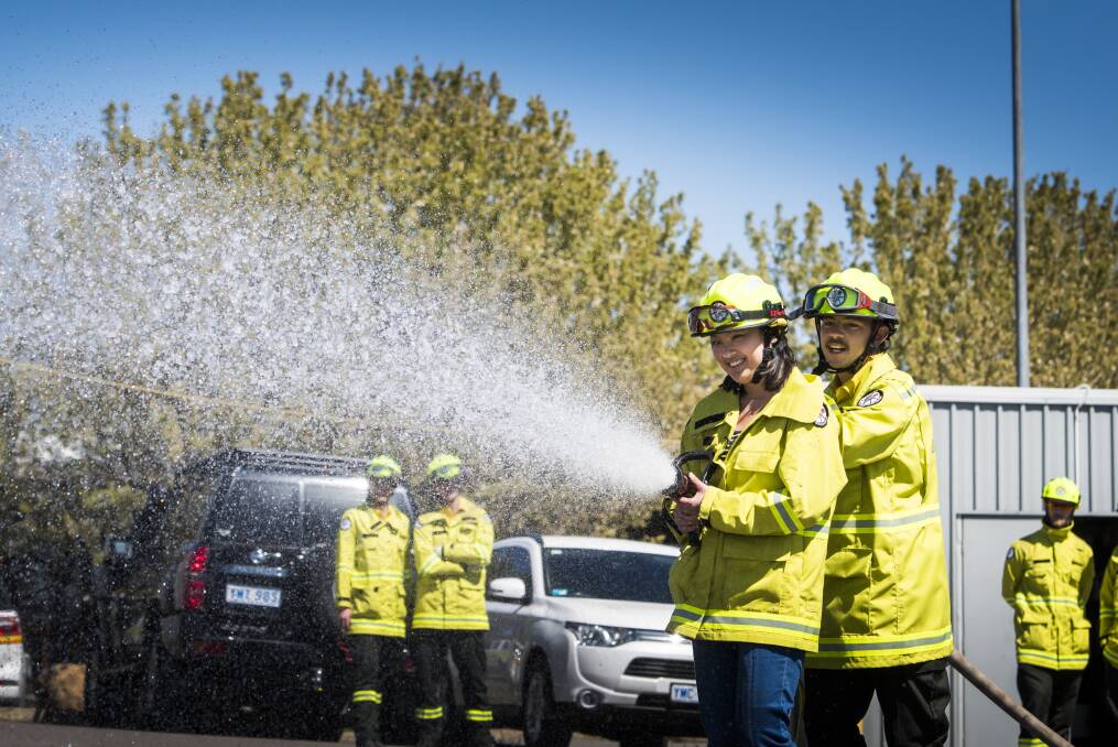 Reporter Han Nguyen tried training as a seasonal firefighter at Stromlo Forrest fire unit. She's partnered with Angus Polhill as they run through hose drills.  Photo: Elesa Kurtz