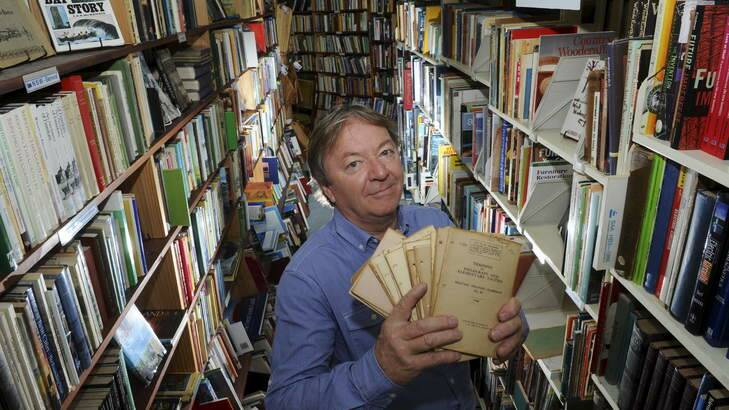 Simon Maddox in his Beyond Q Bookshop in Curtin, with some of the military doctrine   training pamphlets. Photo: Graham Tidy