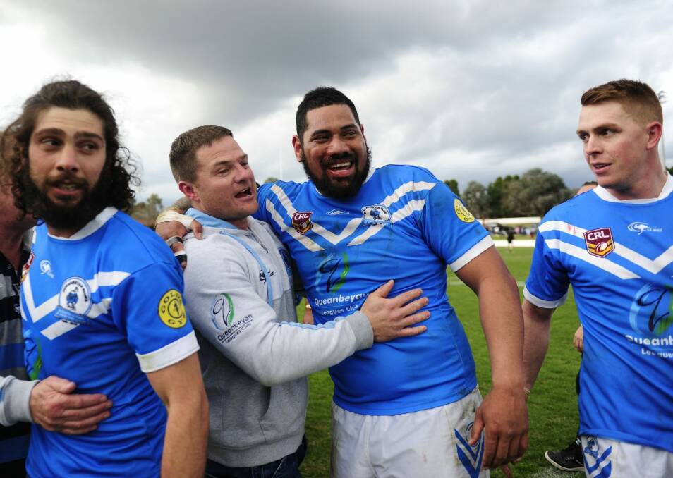 Queanbeyan Blues players celebrate their grand final win last year with coach, Simon Woolford.  Photo: Melissa Adams