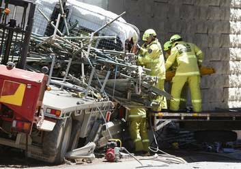 ACT Fire and Rescue members work to free the driver of the truck. Photo: Jeffrey Chan