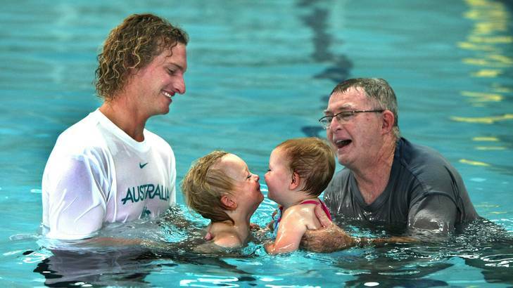 Swimmer Justin Norris with son Coda and Laurie Lawrence with grand-daughter Evie Reid. Photo: Phil Hearne