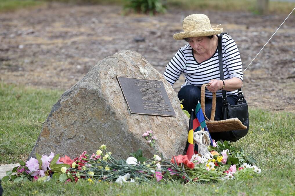 Mary Bush of Turner places flowers at the memorial in Weston Park during Monday's service for people who have lost their lives to drug use. Photo: Jeffrey Chan
