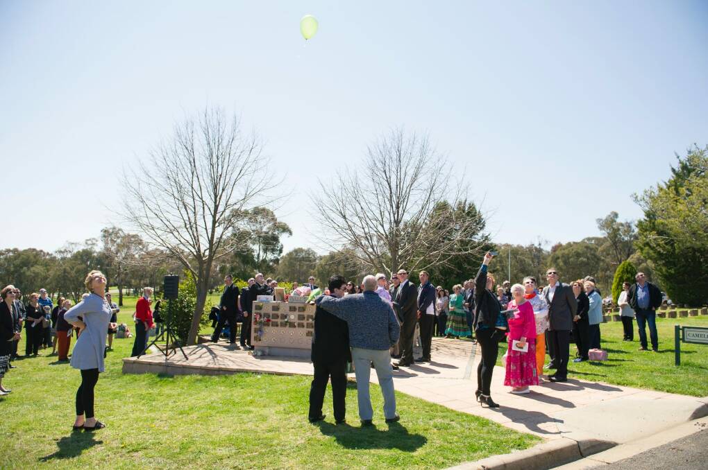 Mourners released green balloons into the sky over Queanbeyan Lawns Cemetery at the end of the service. Photo: Jay Cronan