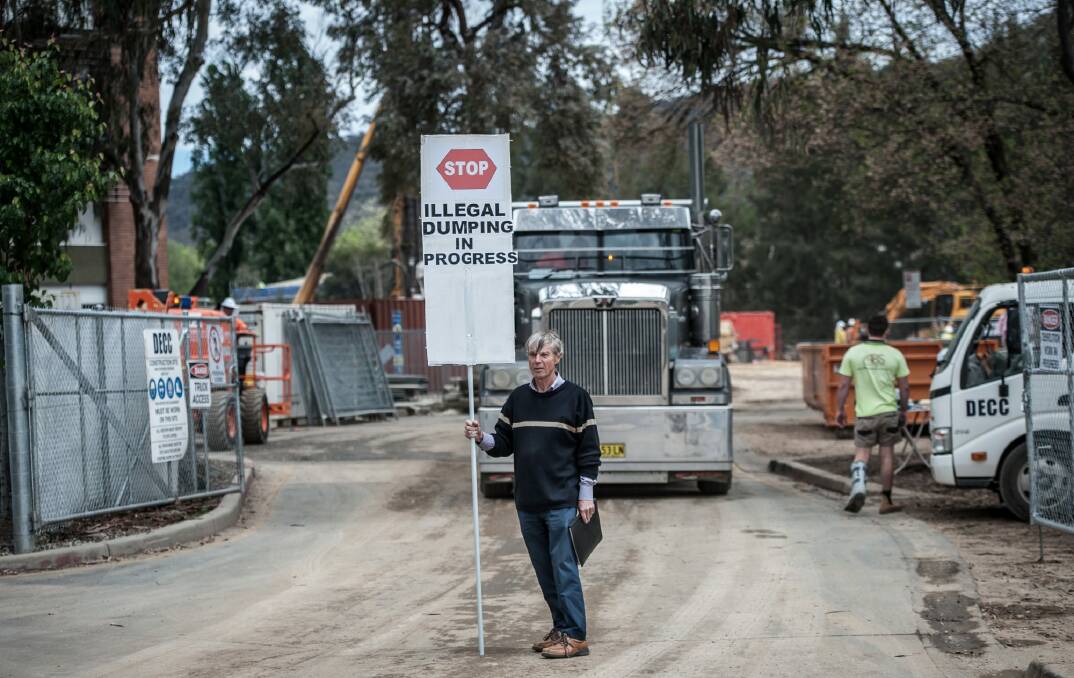 Protest organiser John Connelly stops a moving truck outside the ANU construction site. Photo: Karleen Minney