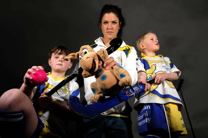 Junior players Elizabeth Harlum (8) and Patrick Compton (5) get serious about the Olympics with Hockeyroo Anna Flanagan after they presented her with a team mascot. Photo: Stuart Walmsley