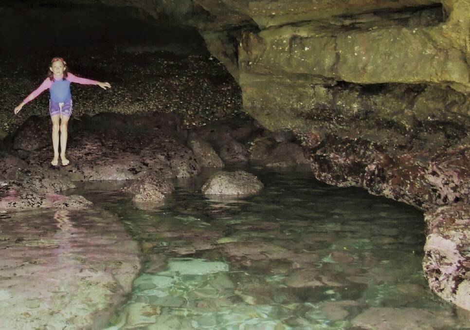 Kiah Feeken explores the cave of singing rocks near North Head. Photo: Erwin Feeken