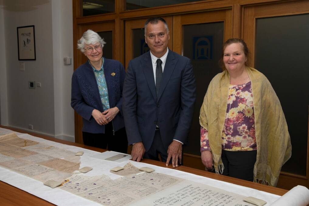 Hilary Rowell (left) with Stan Grant showing him the Larrakia petition, which calls for land rights and political representation for Aboriginal people, when he visited the National Archives last year. 
Also pictured is Rebecca Bateman who worked in the Indigenous Unit with Ms Rowell.

 Photo: Trudie Hargrave