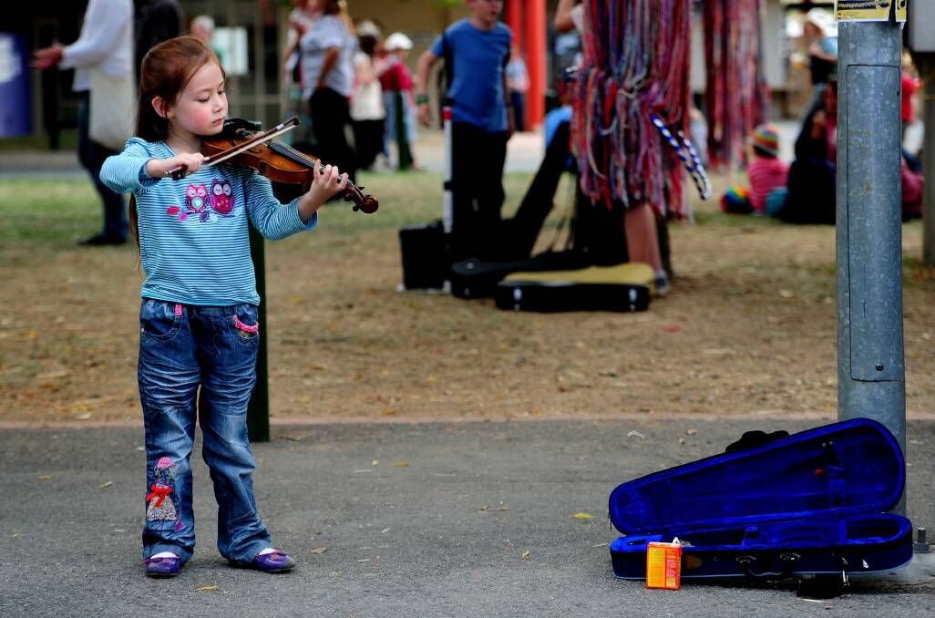 Acacia Ward, then 5, busks at the National Folk Festival in 2013.  Photo: Melissa Adams 