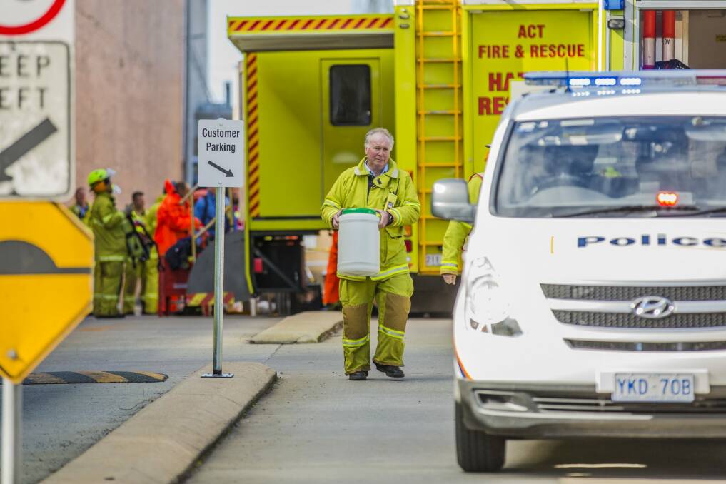 An ACT Fire & Rescue member hands over a suspicious powder found inside the Fyshwick Mail Centre to police. Photo: Jamila Toderas