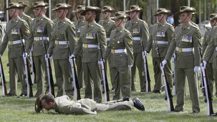 A Federation Guard member collapses during the Centenary of Canberra Foundation Stone ceremony in Canberra. Photo: Andrew Meares