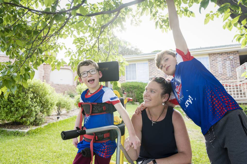 Seven-year-old Lucas Wallace, left, who is affected by cerebral palsy will participate in the Sanitarium Weet-Bix Kids TRYathlon in February. By his side is mum Phyllis Wallace and nine-year-old brother Blake.  Photo: Sitthixay Ditthavong