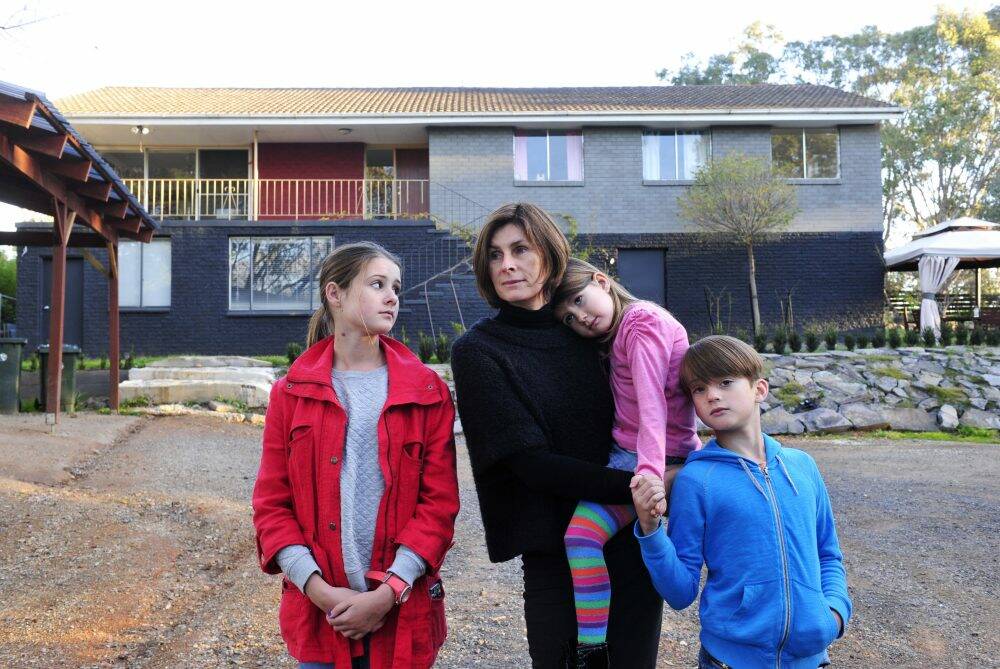 The Ross family: Nathalie with her children, Charlie, 8, Grace,13, and Lulu, 5, outside their family home which is contaminated with Mr Fluffy asbestos.  Photo: Melissa Adams