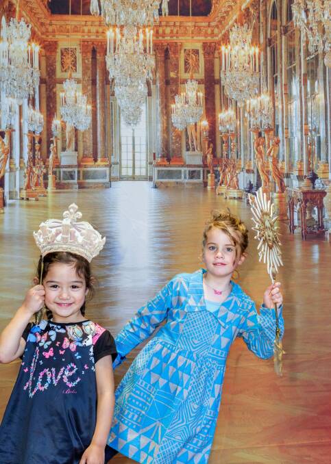 Children pose in front of a photograph from the  Palace of Versailles in France, heralding not only the National Gallery of Australia's next blockbuster, Versailles: Treasures from the Palace, but the gallery's plans to open a permanent, free play space. Photo: Supplied