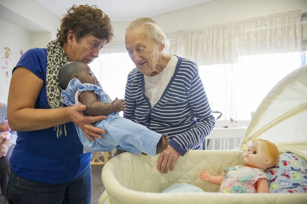 Hands on: Leisure and lifestyle officer Mariella Campbell with Yvonne Harmey and doll George in Uniting Mirinjani Weston's dementia care unit. Photo: Jay Cronan