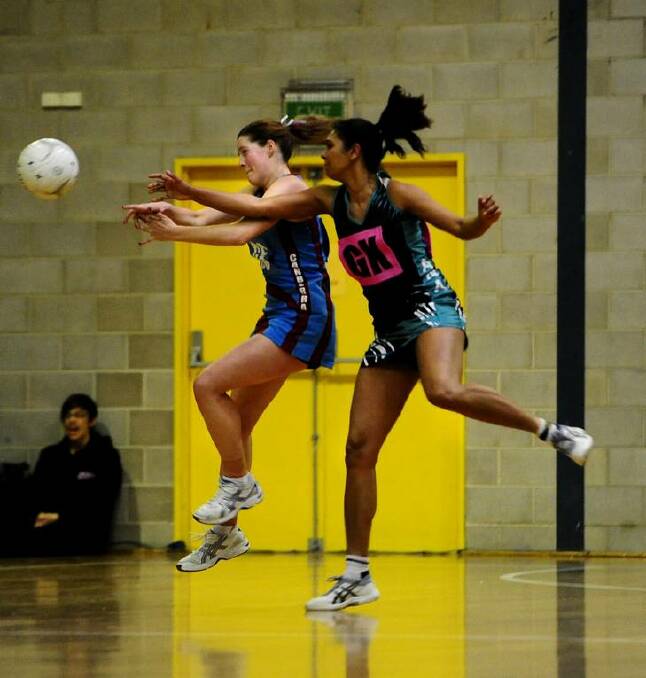 Canberra player, Sam McDonald and Arawang player, Melina Saunders fight for the ball. Photo: Melissa Adams