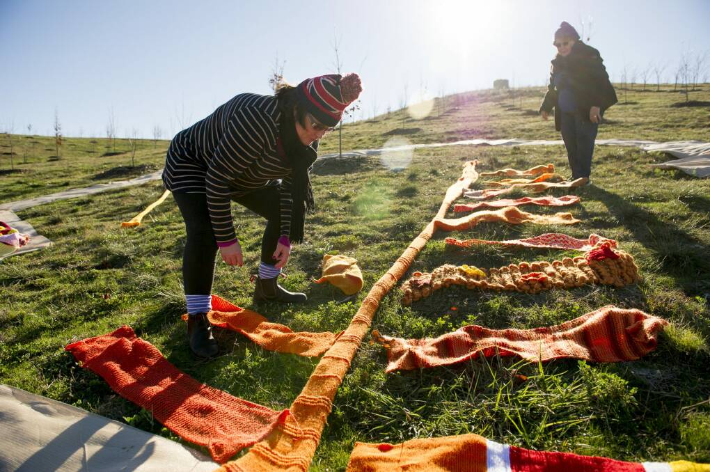 Tabitha Plovits and Jocelyn Plovits installing the world's largest knitted maple leaf ahead of the annual Warm Trees festival at The National Arboretum this July.  Photo: Jay Cronan