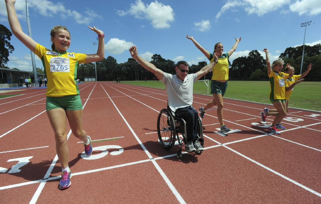 The $7m refurbishment of the Woden athletics track. Commonwealth Games medalist in the Javelin, Kelsey-Lee Roberts, centre, is joined by Woden Little Athletics club members from left Rori Pryor, 11, Adela Russell, 11 and Siena Russell, 10. and paralympian, Richard Nicholson, at the track. Photo: Graham Tidy
