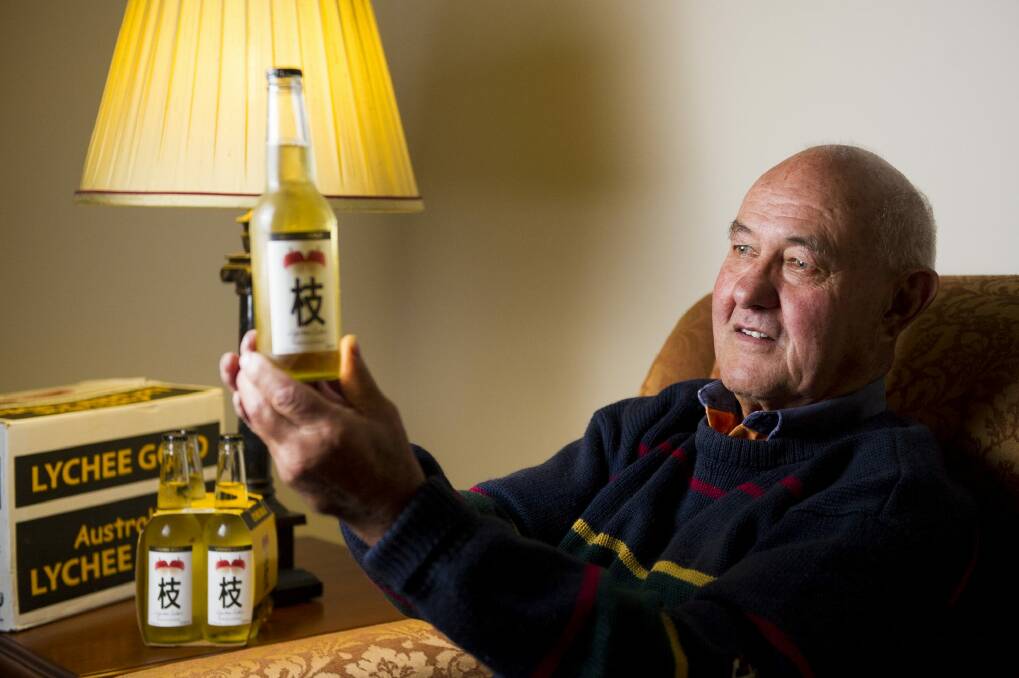 Alan Aston surveys a bottle of his Lychee Gold Cider. 
  Photo: Jay Cronan