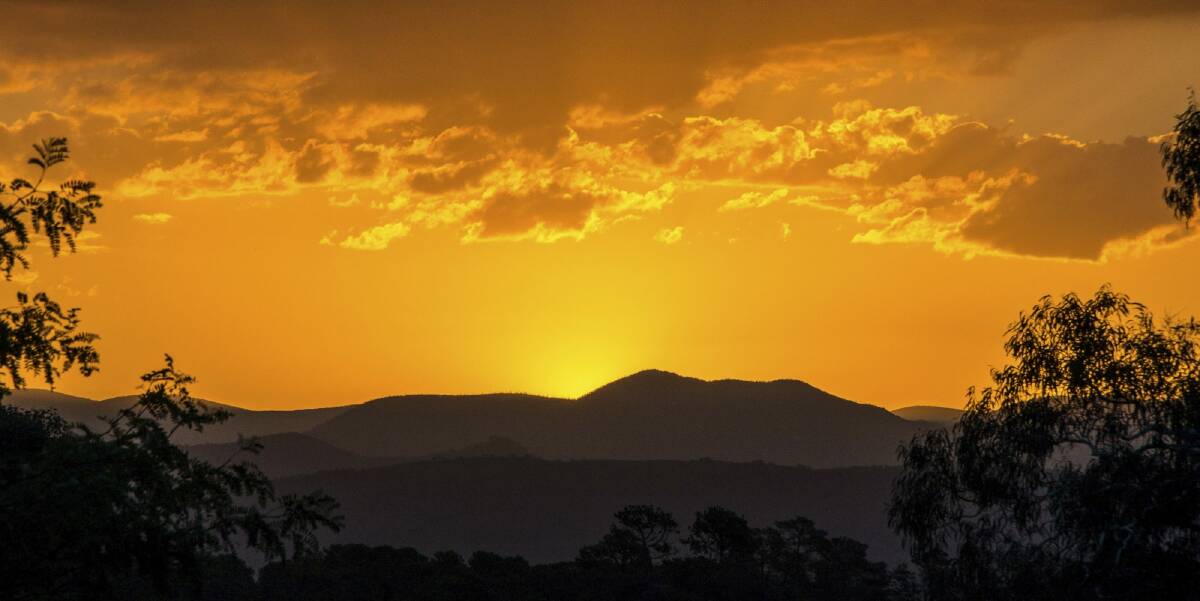 The sun setting behind the Brindabellas. South Canberra residents may also see smoke over there as a hazard reduction burn takes place. Photo: Chris Blunt