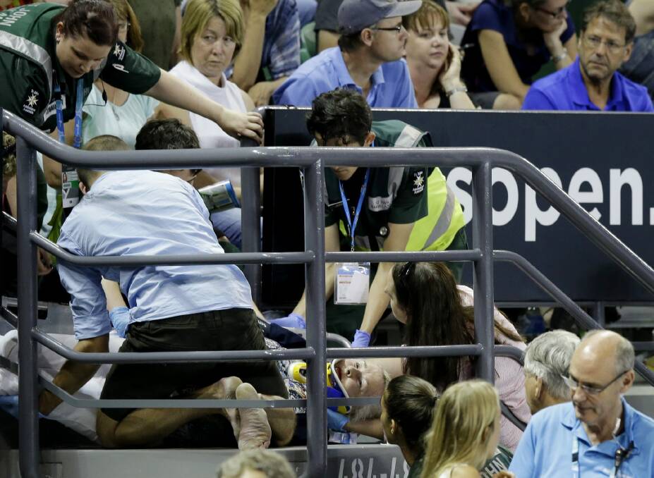 Medical staff attend to the injured fan on a stairwell Photo: AP